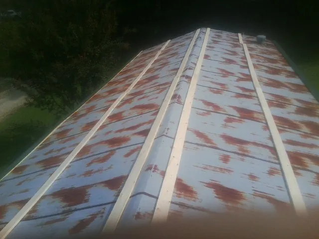 Rusted metal roof panels with new wood purlins before replacement — Storm Damage Roof Repair in Estell Manor by Roofing Brothers