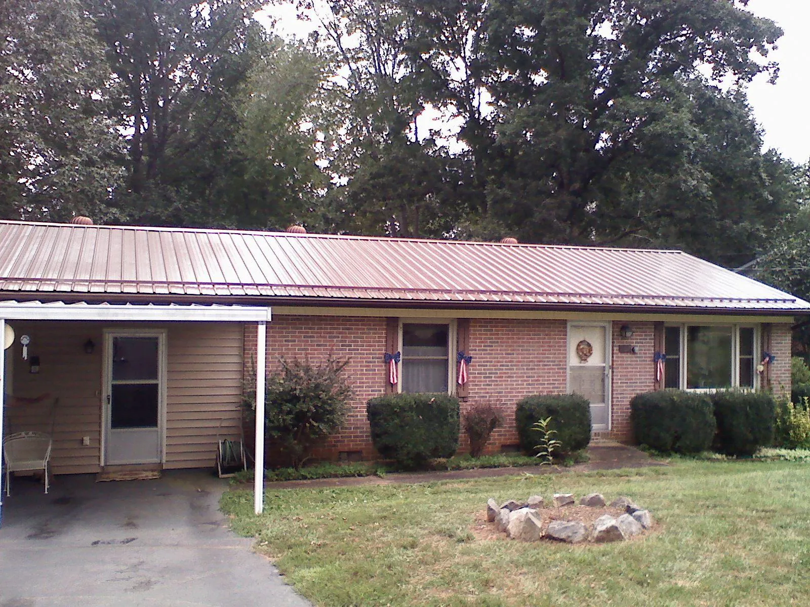 Bronze metal roof and carport on a brick ranch home — Roof Repair work by our crew in Estell Manor